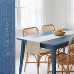 Dining table finished in Evolve Oasis Blue soy wood stain with rattan chairs